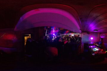 Wide angle photo from a 360 camera of a dj and crowd