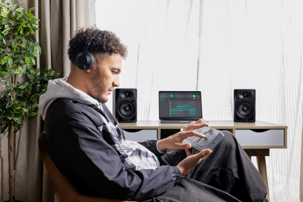 Producer experimenting with chord progressions on Chord Cat while syncing with DAW session in home studio