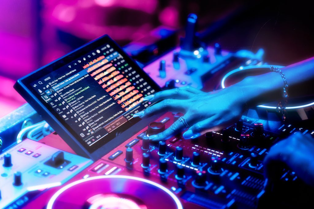 Performance style image of a female Dj using the Joy Coder to load a track onto one of the decks